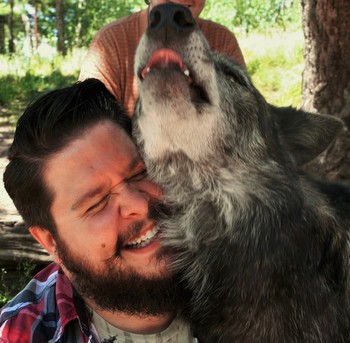 John Whatley with a friendly wolf at the Colorado Wolf and Wildlife Center.