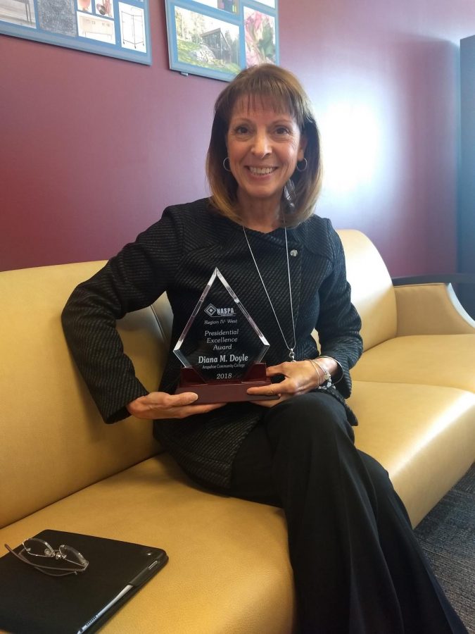 A cheerful Dr. Doyle showcases her Presidential Excellence Award. 