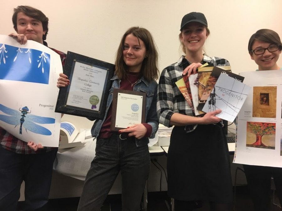 The 2019 Progenitor staff pose with awards, drafts and copies from previous years. 