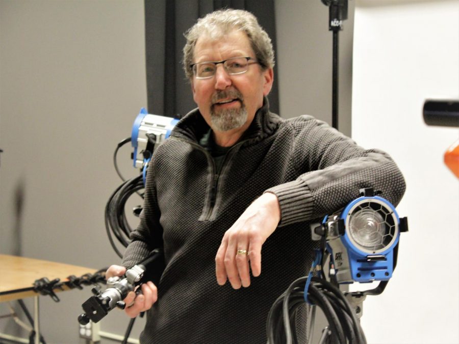Brad Bartholomew, head of the photography department, posing with the lighting equipment, holding a tripod in the Arapahoe Community College Art and Design photography building on Feb. 19th 2019. 