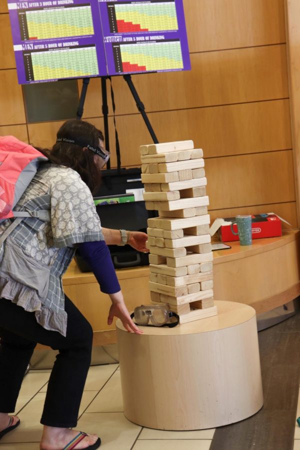 ACC student wears fatal vision goggles and tries to grab a Jenga block on Tues. April 9, 2019. Fatal vision goggles simulates your vision on what it would look like if you were drunk.