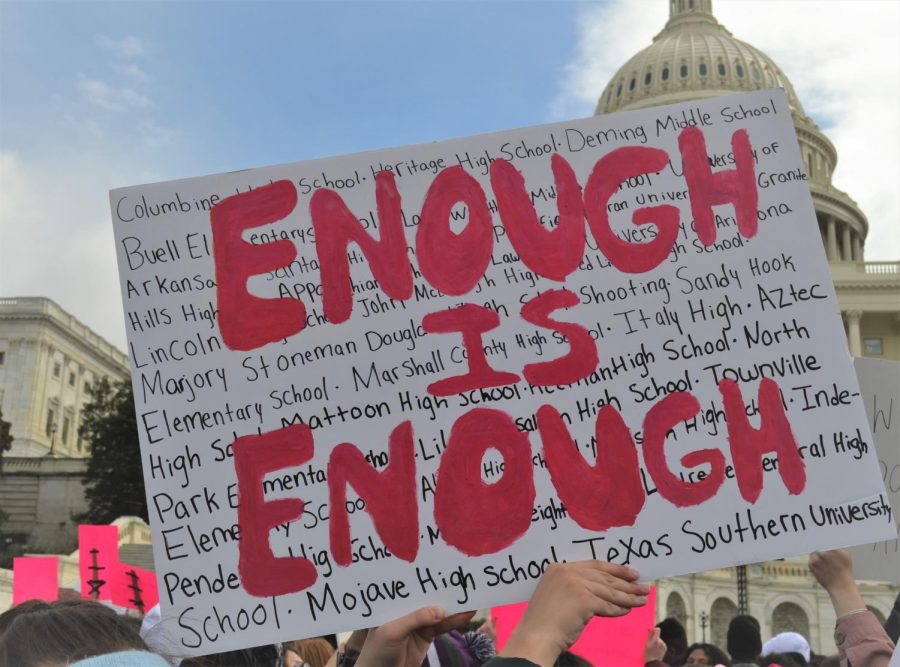 A sign lists the schools that have been struck by mass shootings at a rally taking place in Washington DC. On Mar. 14 2018