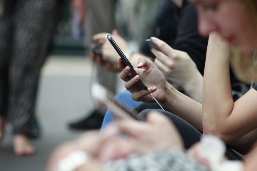 Line of people in the United Kingdom all accompanied by there cellphones in 2017. The average American spends around three hours on their cellular devices daily. 
