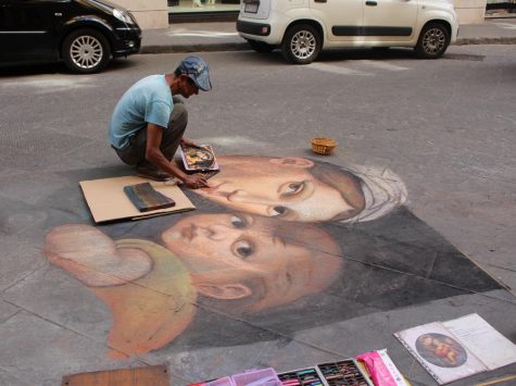 A chalk artists makes a traditional painting out of chalk on a side street in Florence, Italy. Photo taken on Saturday June 15, 2019.