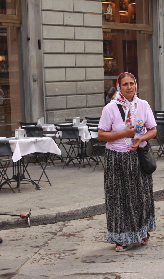 A woman asks commuters for change outside of the Duomo in Florence, Italy.  Photo taken on Saturday, June 15, 2019.