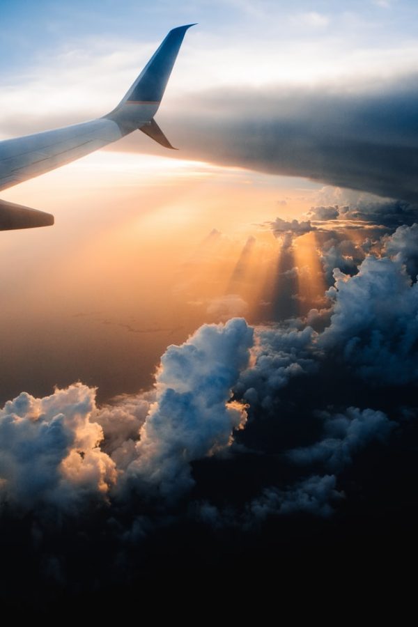 Wing of an airplane in sunset. (Image via Unsplash/Tom Barrett)