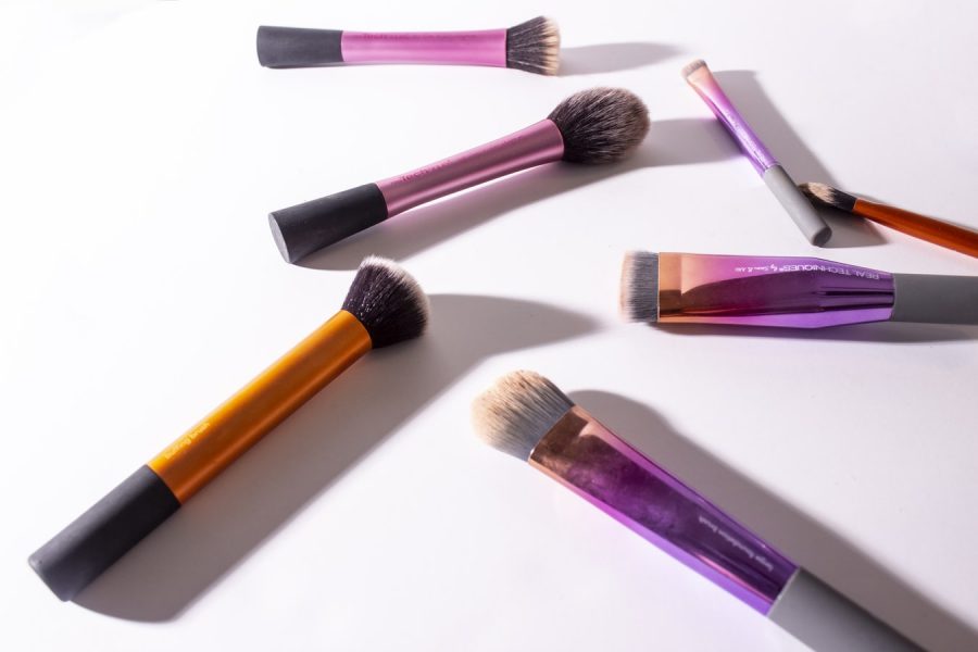 Assorted-color makeup brushes on white surface. (Photo via Unsplash,com/GlowRepose)