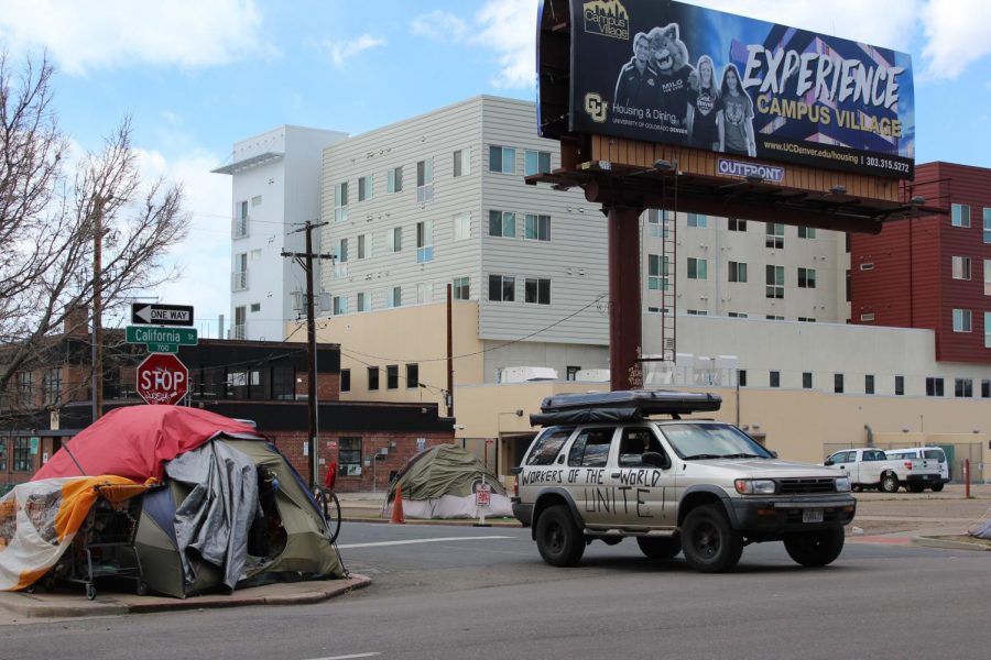 A car with the words workers of the world unite drives past a tent on California St on April 25, 2020.