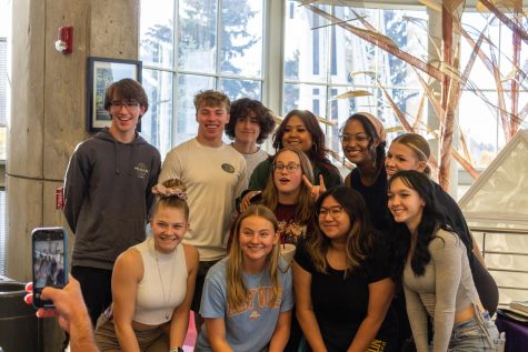 Students gather around Ahja Fox to take a group picture after the event.