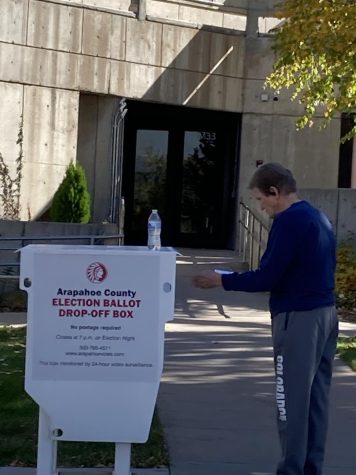 White man puts ballot in white voter drop box.