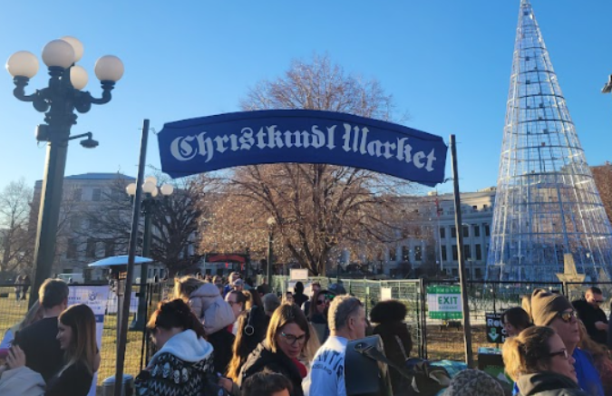 The entrance sign over a crowded marketplace on Dec. 10 for the Christkindlmarket at Civic Center Park. Image via Shelby Whiteaker.

