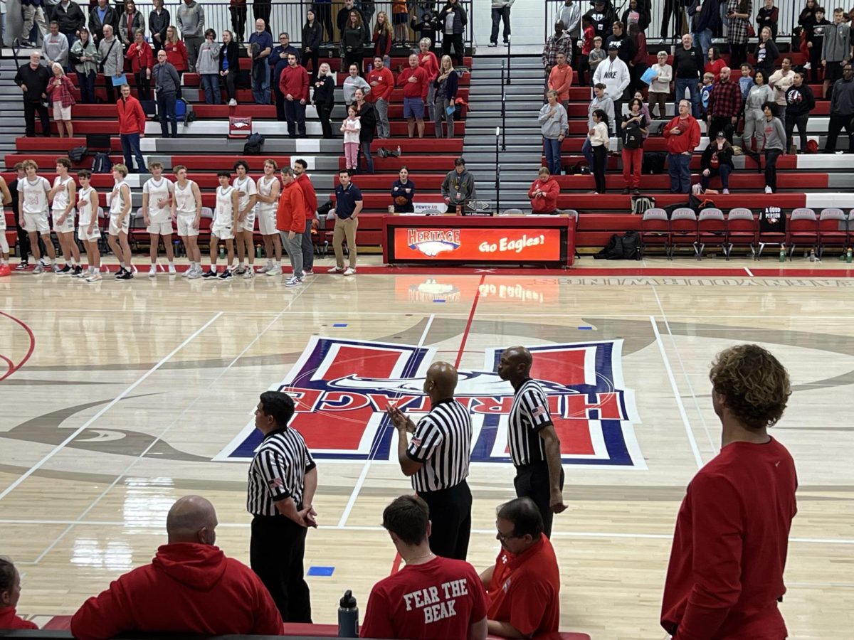 Heritage High School administration tries to get the Star Spangled Banner playing as the coaches and team look on. 12.06.2023