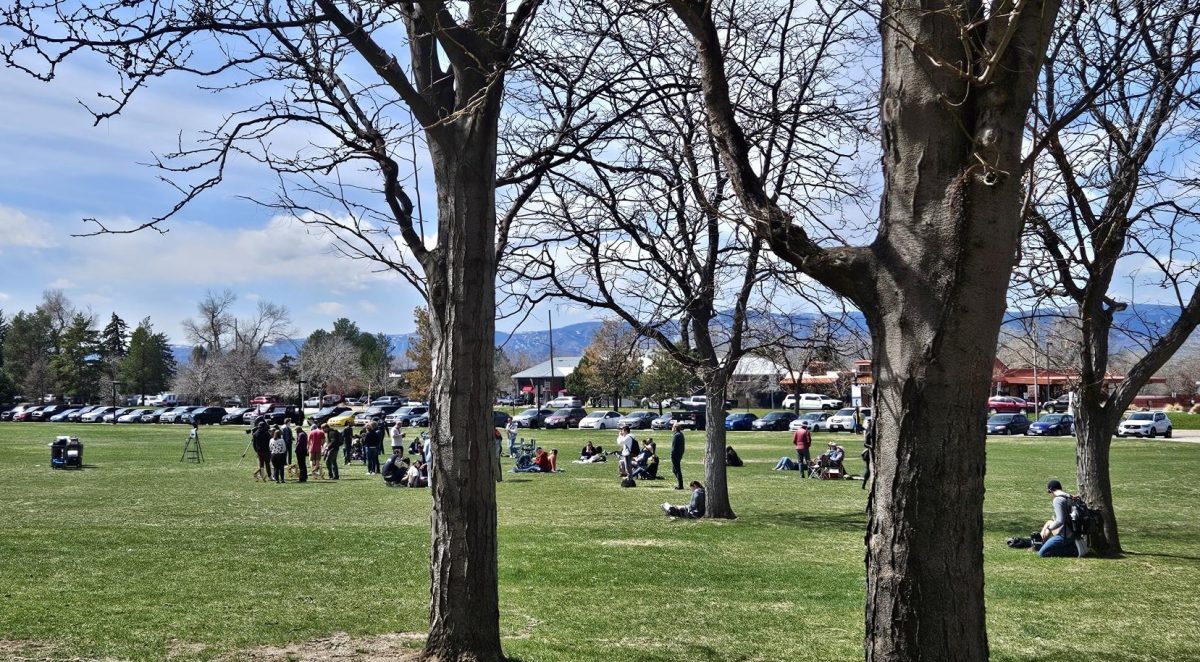 People gather for the solar eclipse viewing party on the west lawn at Arapahoe Community College on Monday, April 8, 2024.