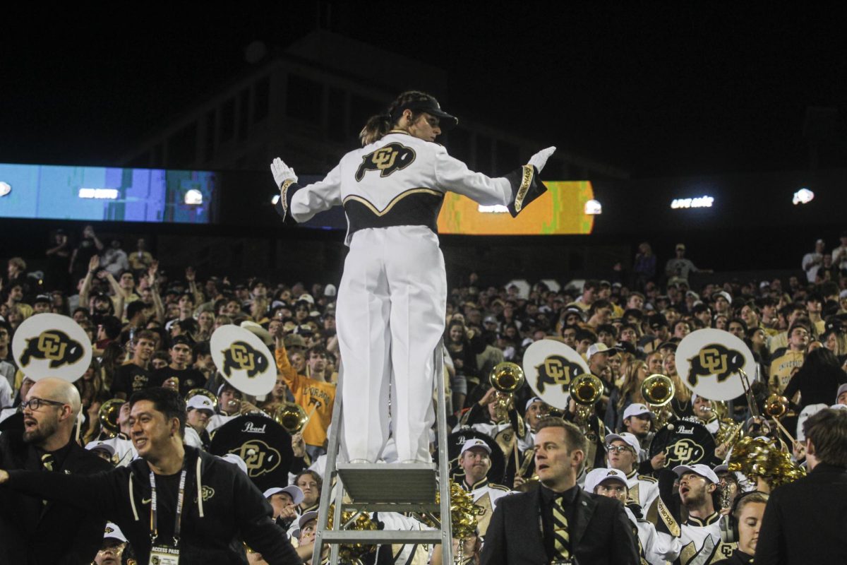 The drum major for the CU Marching Band leads the band in between downs. 