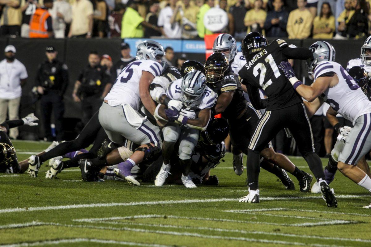 Kansas State running back, DJ Giddens pushes through CU defenders into the end zone. Giddens finished the game with 182 rushing yards. 