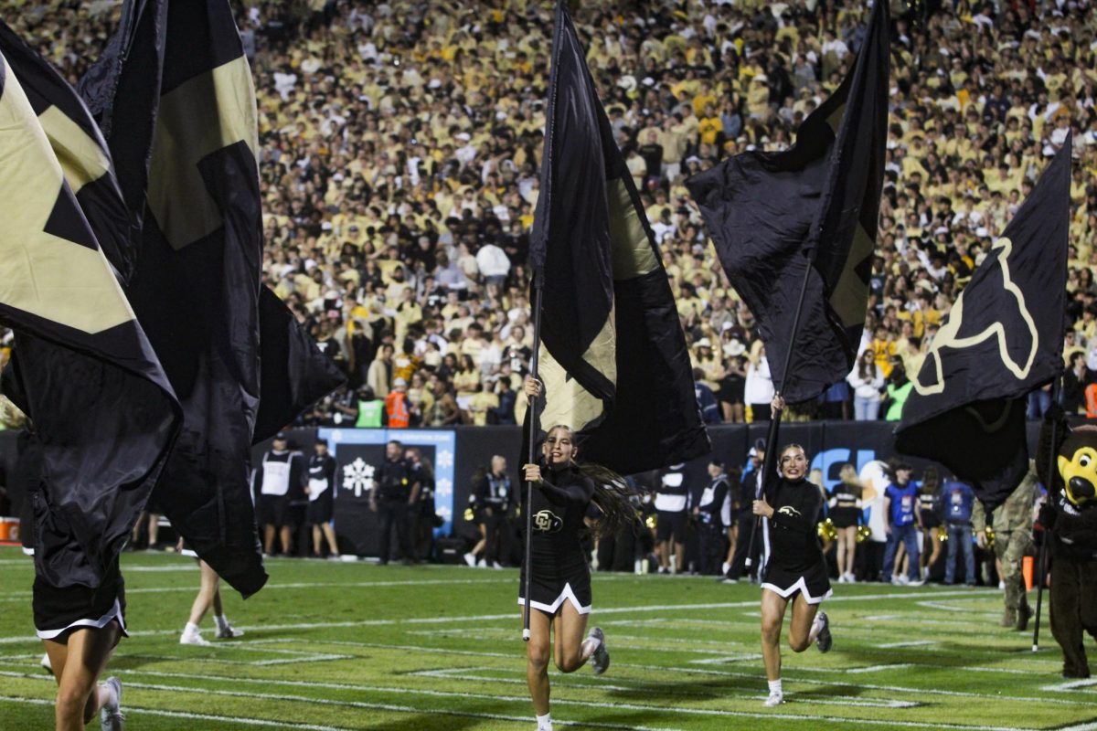 CU dance team members run across the end zone after the offense scored a touchdown.