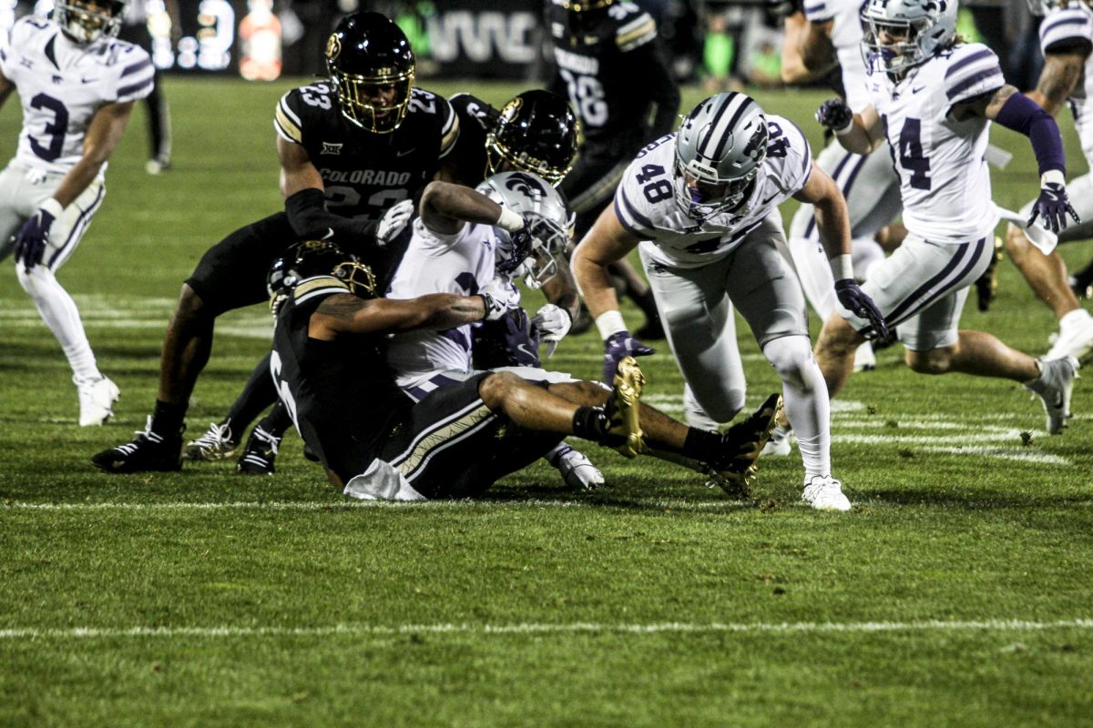 A Kansas State wide receiver is brought down by a CU defender.