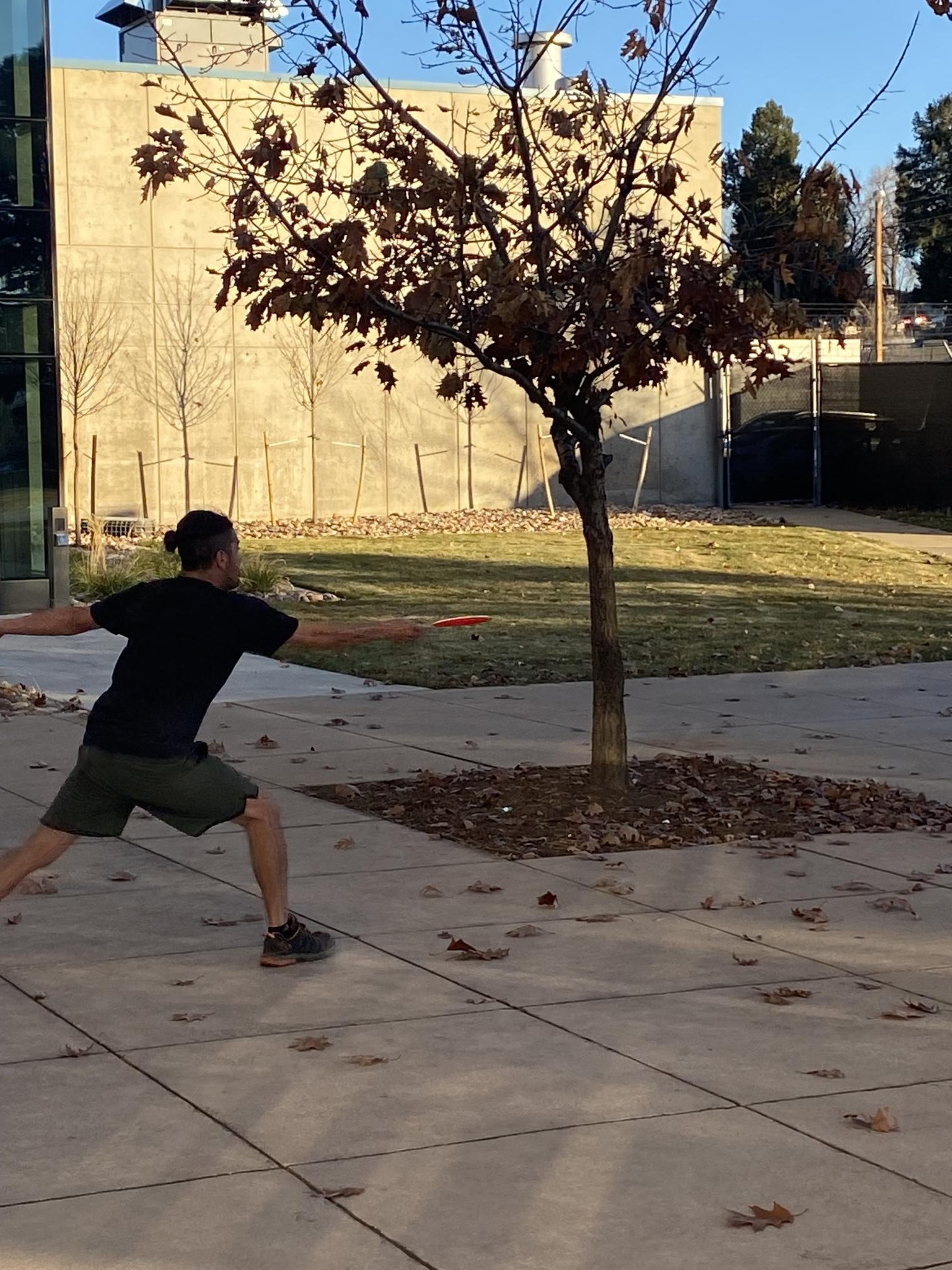 Member of the Littleton community in a new location winding up to throw the frisbee