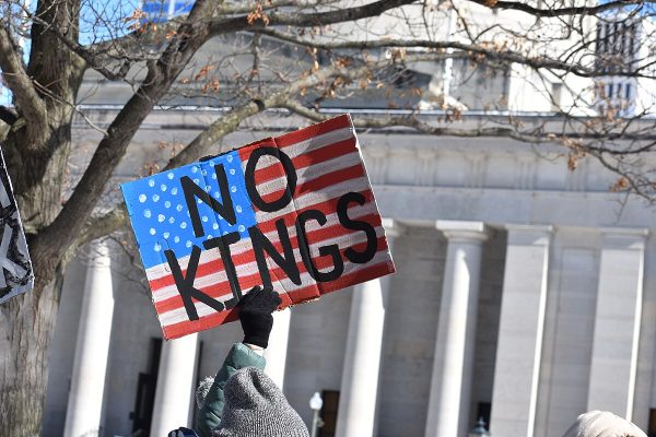 Protester holding a "No Kings" sign during a 50501 movement protest in the Capitol Square, Columbus, Ohio. Courtesy of Wikicommons. 

Text is available under the Creative Commons Attribution-ShareAlike 4.0 License; additional terms may apply.